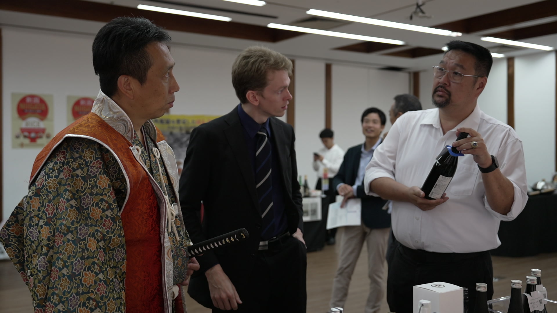 An exhibitor explaining sake at a business meeting booth